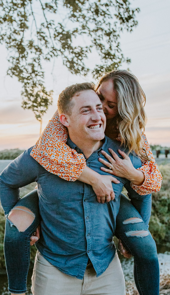 Sacramento River Engagement Session Northern California Weiner dog engagement shoot outfit inspo engagement photos with dog couples shoot posing golden hour sacramento river rachel christopherson photography piggy back cheek kiss