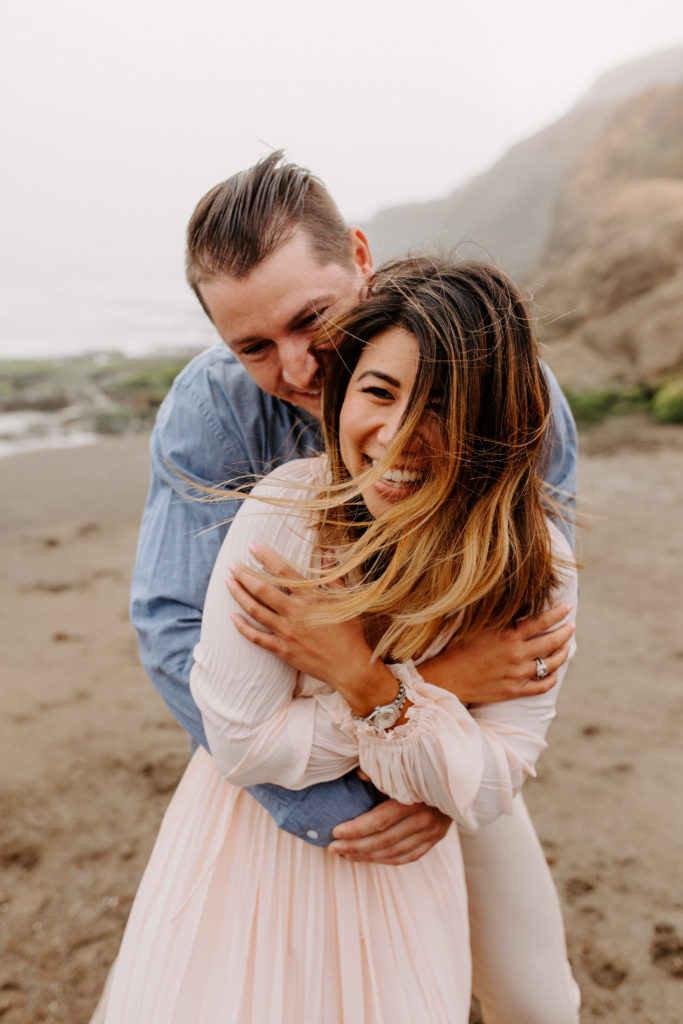close up of man hugging woman, Marin Headlands Engagement Photos, Bay Area Engagement Photos, Bay Area Engagement Photo Locations, Engagement Photo Outfits, Bay Area Beach Engagement Photos, Dog Friendly Bay Area Beaches, Best Locations for Bay Area Engagement Photos, San Francisco Engagement Photos, What to Wear for Engagement Photos, Engagement Photos with dogs, Rachel Christopherson Photography LLC