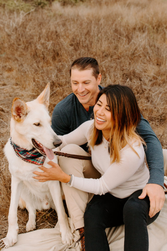 Couple sitting in grass with white dog, Marin Headlands Engagement Photos, Bay Area Engagement Photos, Bay Area Engagement Photo Locations, Engagement Photo Outfits, Coastal Bay Area Engagement Photos, Dog Friendly Bay Area Beaches, Best Locations for Bay Area Engagement Photos, San Francisco Engagement Photos, What to Wear for Engagement Photos, Engagement Photos with dogs, Rachel Christopherson Photography LLC
