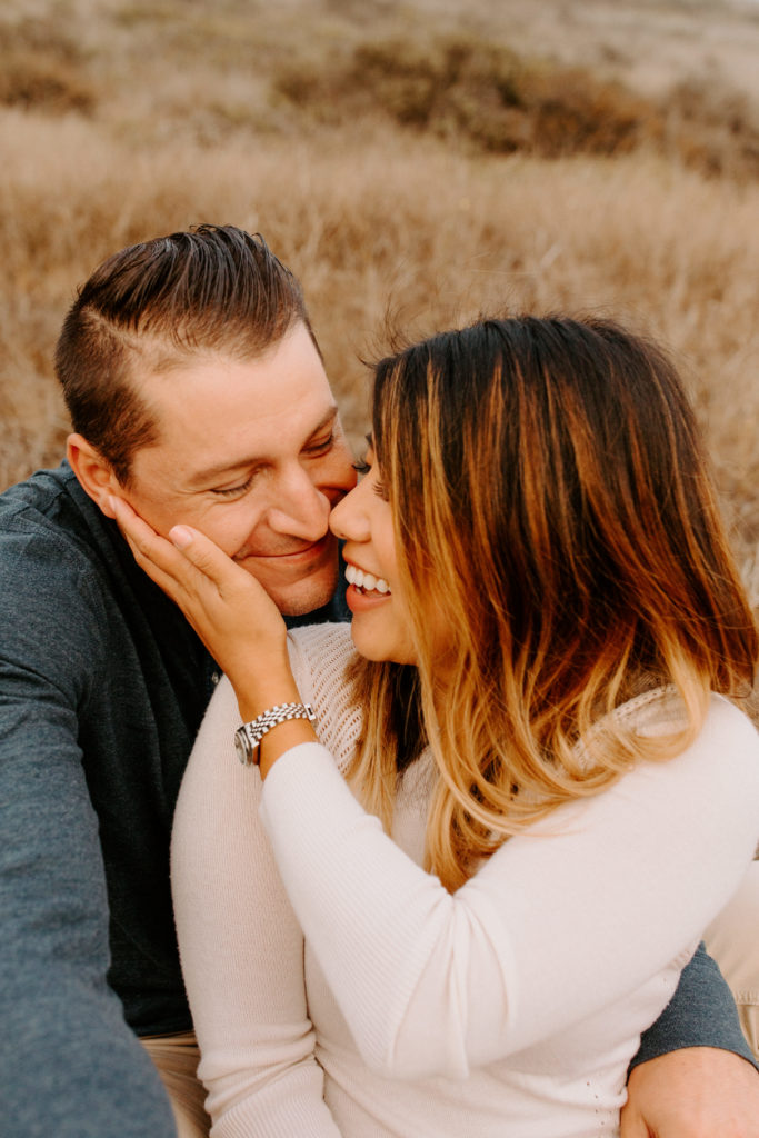 couple laughing while woman holds his face, Marin Headlands Engagement Photos, Bay Area Engagement Photos, Bay Area Engagement Photo Locations, Engagement Photo Outfits, Coastal Bay Area Engagement Photos, Dog Friendly Bay Area Beaches, Best Locations for Bay Area Engagement Photos, San Francisco Engagement Photos, What to Wear for Engagement Photos, Engagement Photos with dogs, Rachel Christopherson Photography LLC