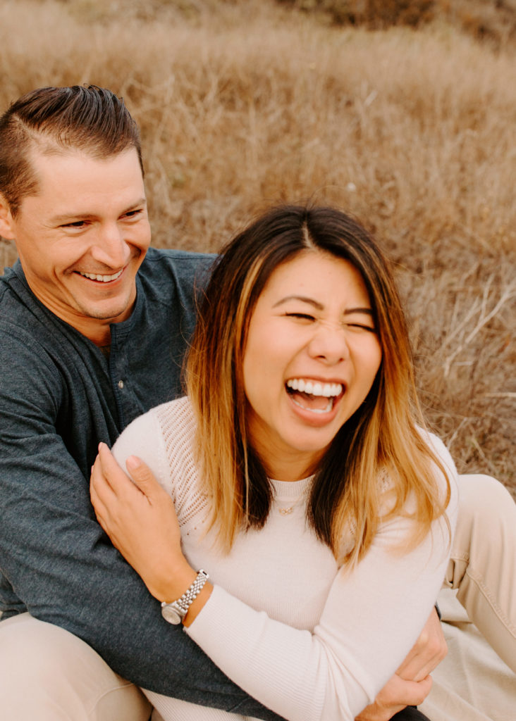 woman laughing with man on grass, Marin Headlands Engagement Photos, Bay Area Engagement Photos, Bay Area Engagement Photo Locations, Engagement Photo Outfits, Coastal Bay Area Engagement Photos, Dog Friendly Bay Area Beaches, Best Locations for Bay Area Engagement Photos, San Francisco Engagement Photos, What to Wear for Engagement Photos, Engagement Photos with dogs, Rachel Christopherson Photography LLC