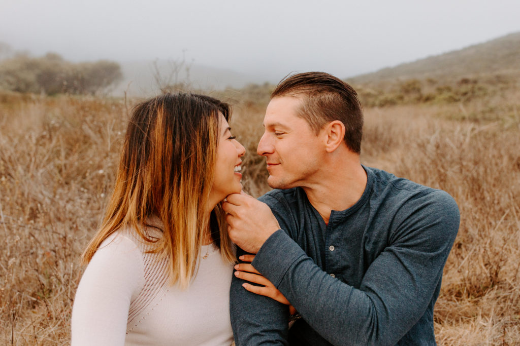 close up on couple leaning in towards each other, Marin Headlands Engagement Photos, Bay Area Engagement Photos, Bay Area Engagement Photo Locations, Engagement Photo Outfits, Coastal Bay Area Engagement Photos, Dog Friendly Bay Area Beaches, Best Locations for Bay Area Engagement Photos, San Francisco Engagement Photos, What to Wear for Engagement Photos, Engagement Photos with dogs, Rachel Christopherson Photography LLC