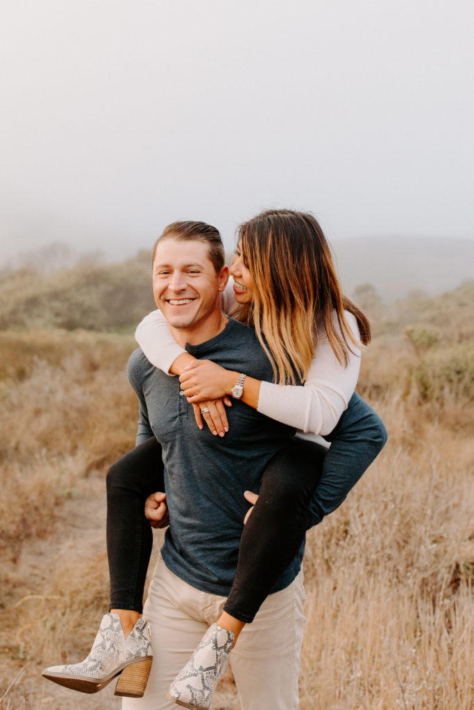 couple piggy back ride, Marin Headlands Engagement Photos, Bay Area Engagement Photos, Bay Area Engagement Photo Locations, Engagement Photo Outfits, Coastal Bay Area Engagement Photos, Dog Friendly Bay Area Beaches, Best Locations for Bay Area Engagement Photos, San Francisco Engagement Photos, What to Wear for Engagement Photos, Engagement Photos with dogs, Rachel Christopherson Photography LLC