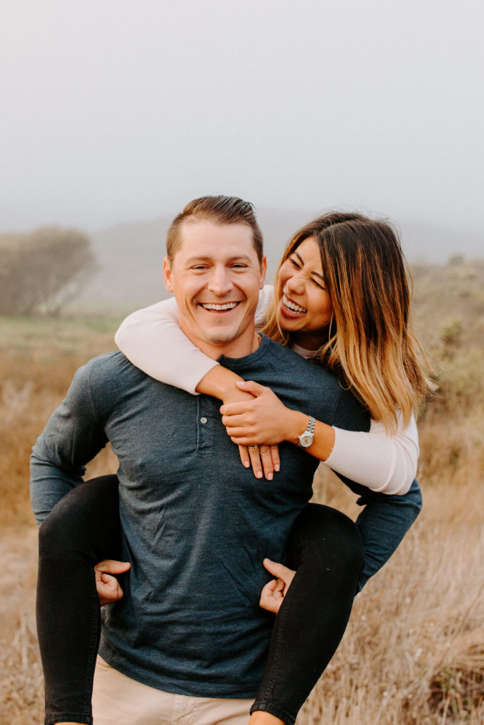 close up of couple in a piggy back, Marin Headlands Engagement Photos, Bay Area Engagement Photos, Bay Area Engagement Photo Locations, Engagement Photo Outfits, Coastal Bay Area Engagement Photos, Dog Friendly Bay Area Beaches, Best Locations for Bay Area Engagement Photos, San Francisco Engagement Photos, What to Wear for Engagement Photos, Engagement Photos with dogs, Rachel Christopherson Photography LLC