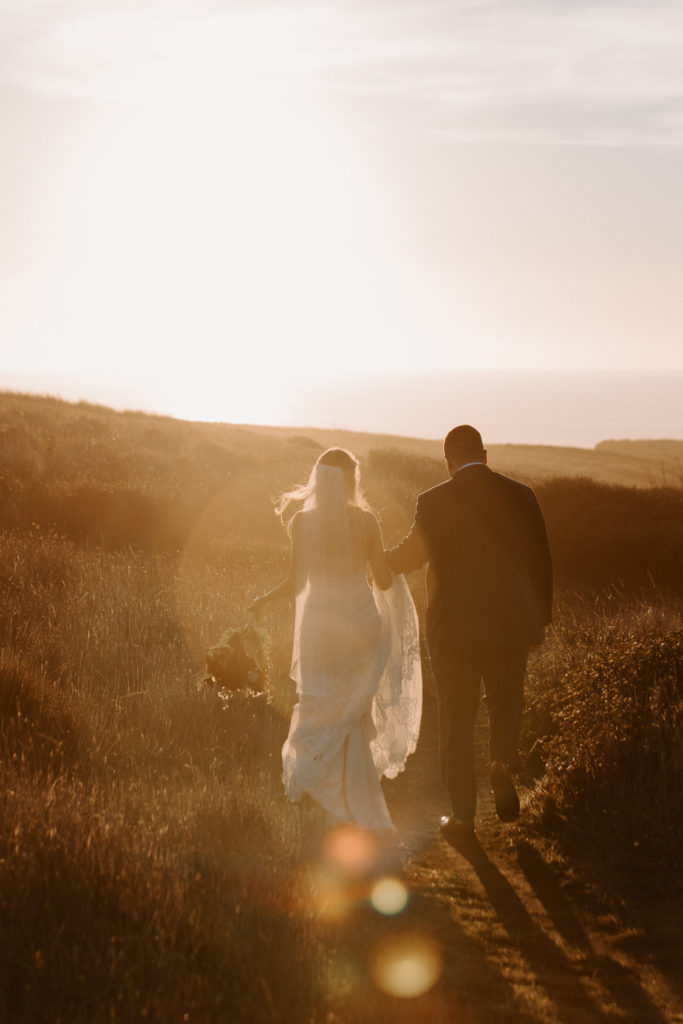 bride and groom walking with sun flare, Mendocino elopement, mendocino wedding, christmas elopement, best places to elope in california, norcal elopement, northern california elopement, elopement inspo, california coast elopement, mendocino california elopement, Rachel Christopherson Photography  