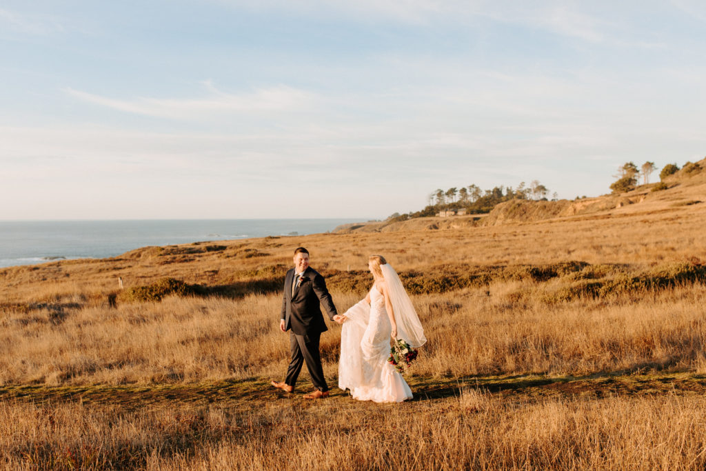 bride and groom walking in field by ocean, Mendocino elopement, mendocino wedding, christmas elopement, best places to elope in california, norcal elopement, northern california elopement, elopement inspo, california coast elopement, mendocino california elopement, Rachel Christopherson Photography 