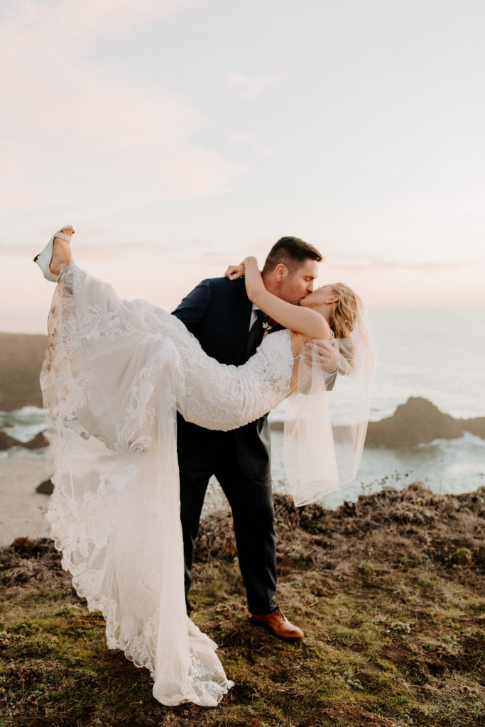 groom holding bride on ocean cliff, Mendocino elopement, mendocino wedding, christmas elopement, best places to elope in california, norcal elopement, northern california elopement, elopement inspo, california coast elopement, mendocino california elopement, Rachel Christopherson Photography 