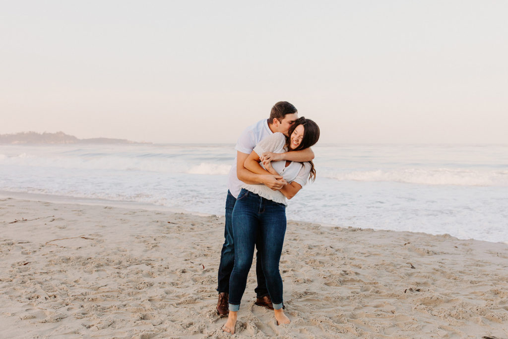 hug from behind on beach, Carmel CA Engagement Photos, Monterey Engagement Photos, Monterey Engagement Photo Locations, Engagement Photo Outfits, California Beach Engagement Photos, Best Locations for Monterey Engagement Photos, What to Wear for Engagement Photos, Rachel Christopherson Photography LLC