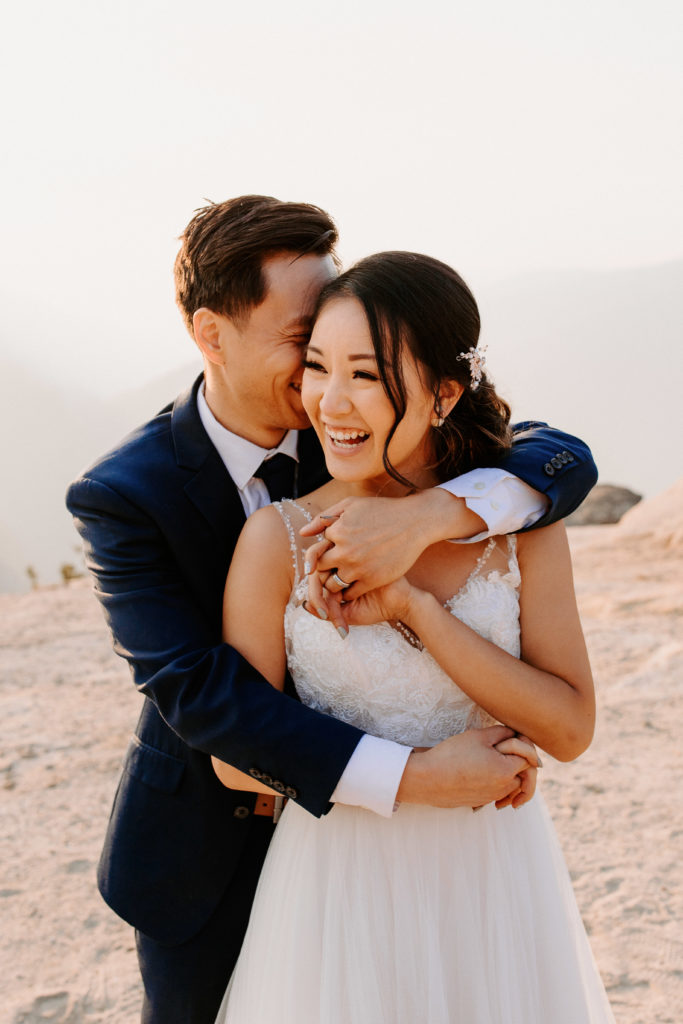 photo of groom arms wrapped around bride from behind, Taft Point elopement, Yosemite Elopement, Glacier Point Elopement, best places to elope in california, northern california elopement, Rachel Christopherson Photography