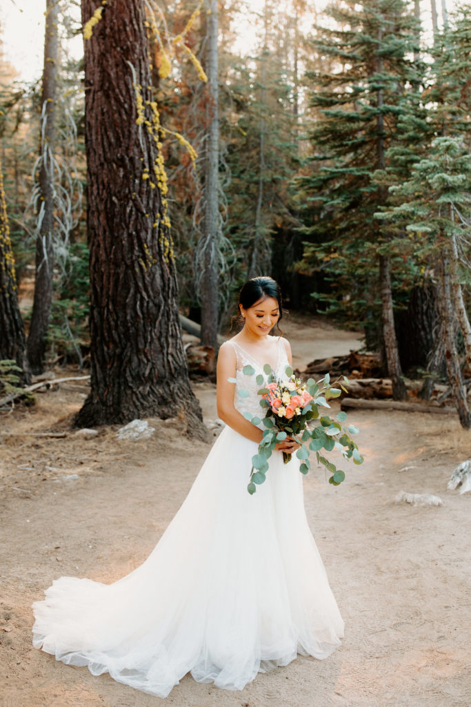 bride in forest, bridal bouquet, bride looking at bouquet, bridal portrait, adventurous bride, Taft Point elopement, Yosemite Elopement, Glacier Point Elopement, best places to elope in california, northern california elopement, Rachel Christopherson Photography