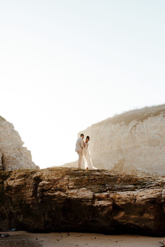 bride and groom on beach cliff, Santa cruz wedding, santa cruz elopement, santa cruz wedding photographer, santa cruz elopement photographer, big sur elopement, boho beach bride, california boho elopement, boho wedding dress, best places to elope in California, California elopement, California beach elopement, boho bride inspo, Rachel Christopherson Photograph