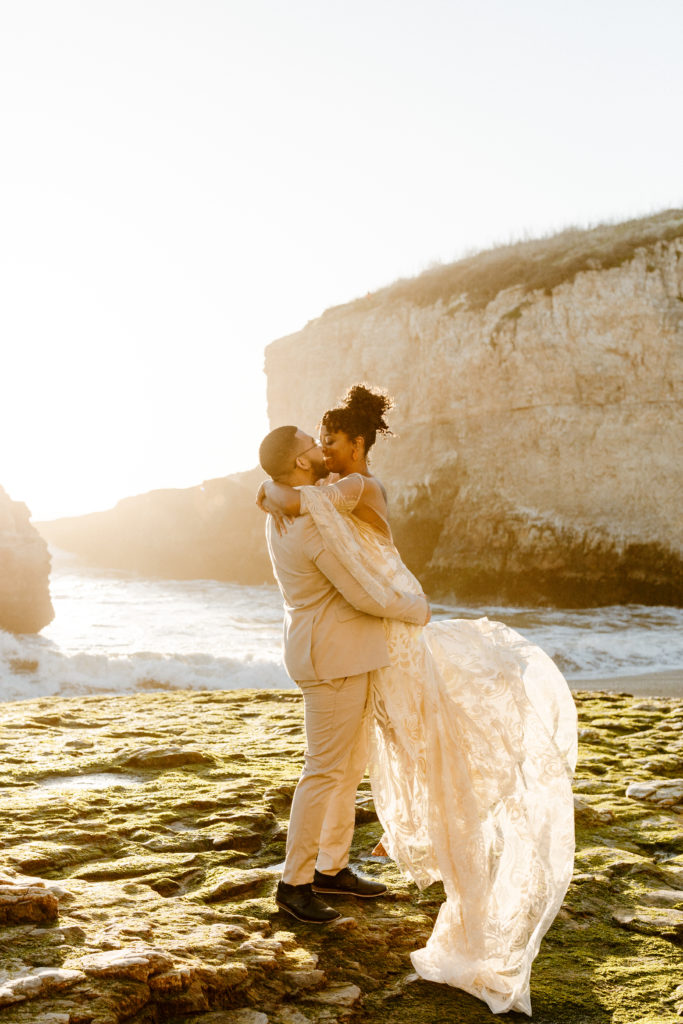 groom lifting bride at sunset, Santa cruz wedding, santa cruz elopement, santa cruz wedding photographer, santa cruz elopement photographer, big sur elopement, boho beach bride, california boho elopement, boho wedding dress, best places to elope in California, California elopement, California beach elopement, boho bride inspo, Rachel Christopherson Photography