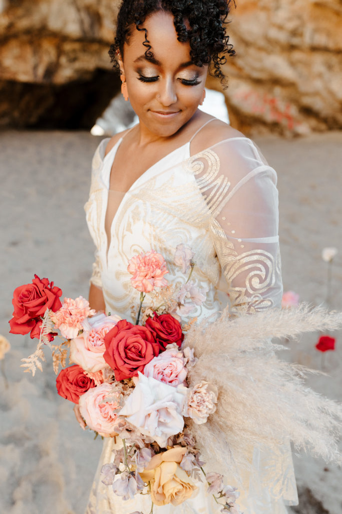 boho bride looking at bouquet, Santa cruz wedding, santa cruz elopement, santa cruz wedding photographer, santa cruz elopement photographer, big sur elopement, boho beach bride, california boho elopement, best places to elope in California, California elopement, California beach elopement, boho bride inspo, Rachel Christopherson Photography
