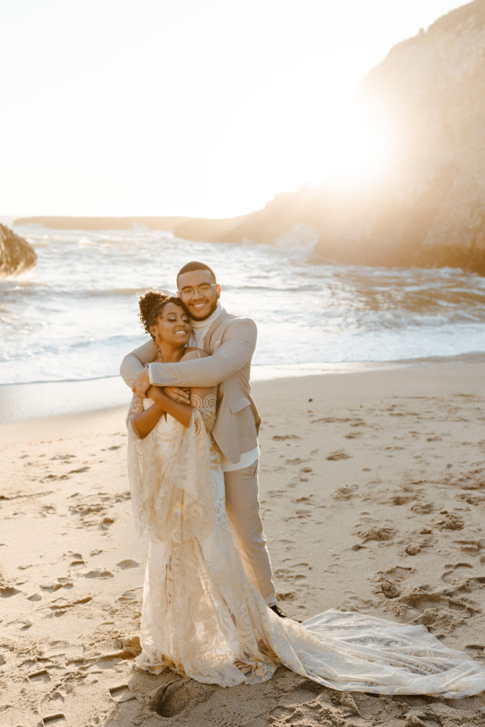 groom hugging bride from behind, Santa cruz wedding, santa cruz elopement, santa cruz wedding photographer, santa cruz elopement photographer, big sur elopement, boho beach bride, california boho elopement, boho wedding dress, best places to elope in California, California elopement, California beach elopement, boho bride inspo, Rachel Christopherson Photography