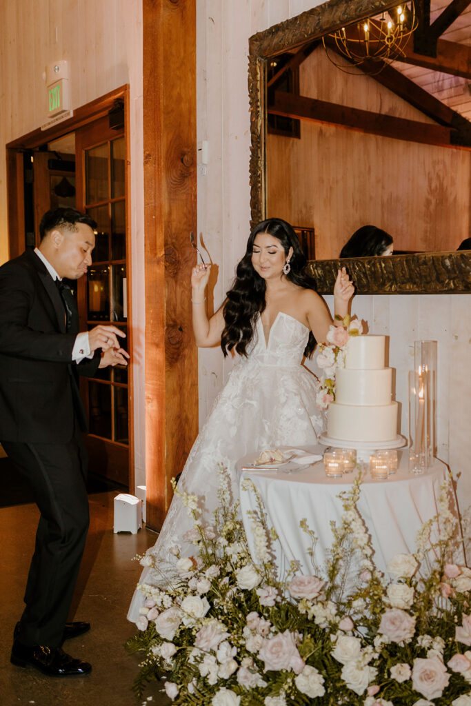 Rachel C Photography - bride and groom cut cake, simple white wedding with flower details
