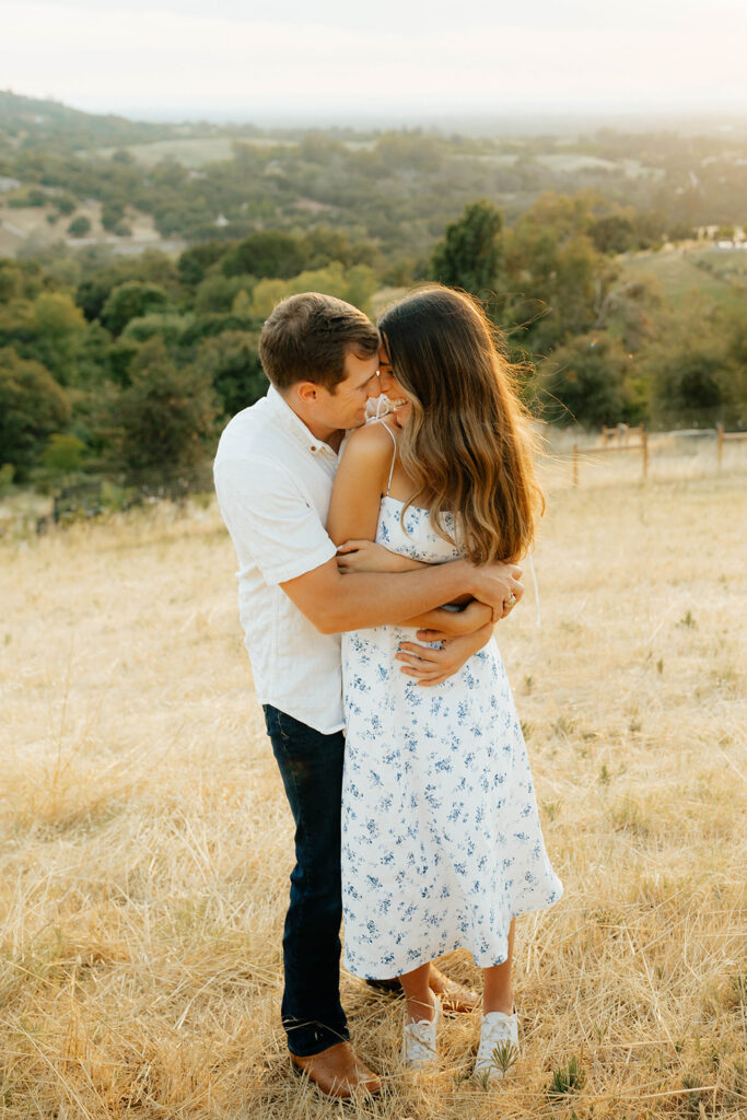 Couple posing for romantic field engagement photos in Auburn, California