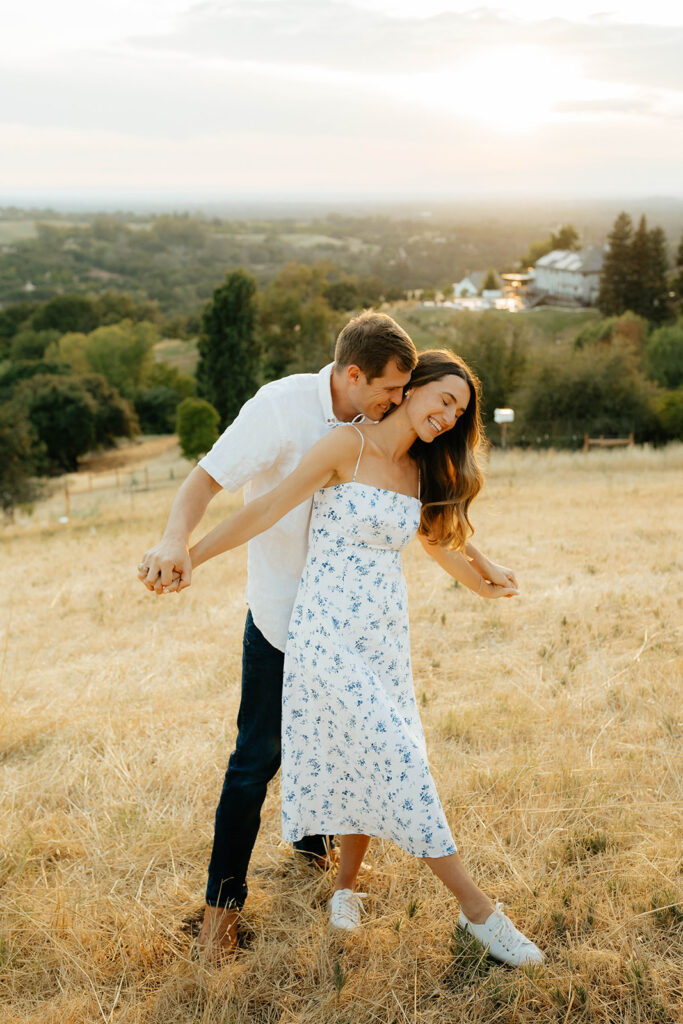 Couple posing for romantic field engagement photos in Auburn, California