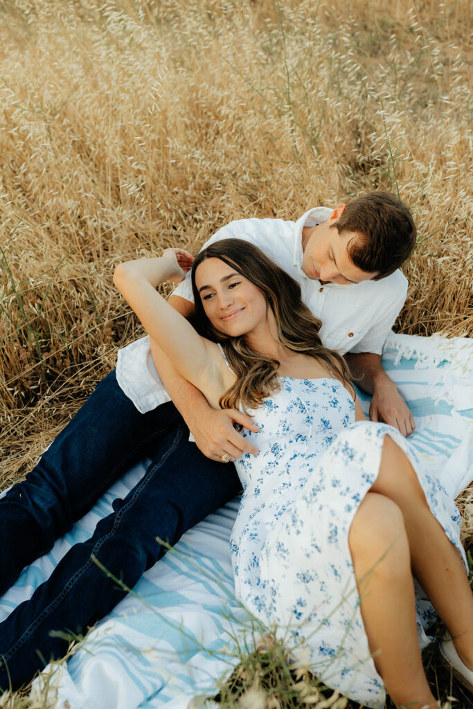 Couple posing for romantic field engagement photos in Auburn, California
