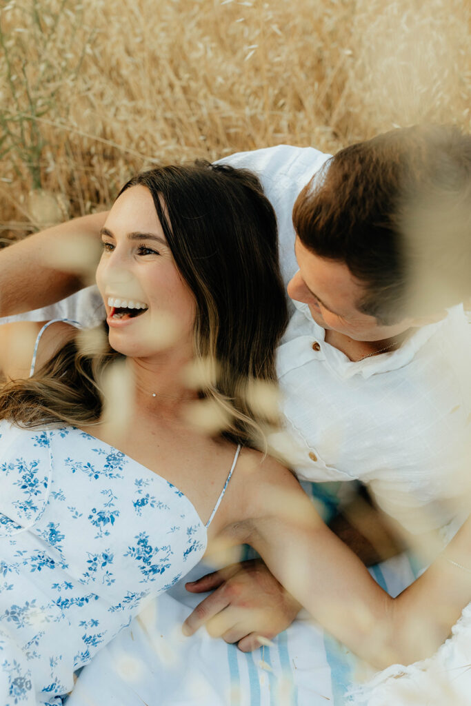 Couple posing for romantic field engagement photos in Auburn, California