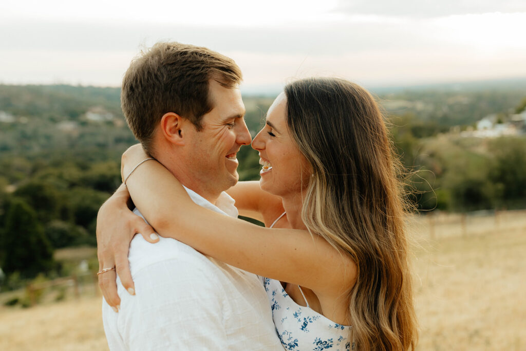 Couple posing for romantic field engagement photos in Auburn, California