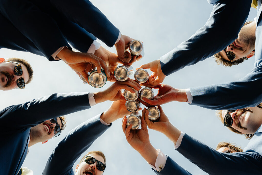 Groom and groomsmen toasting their beers