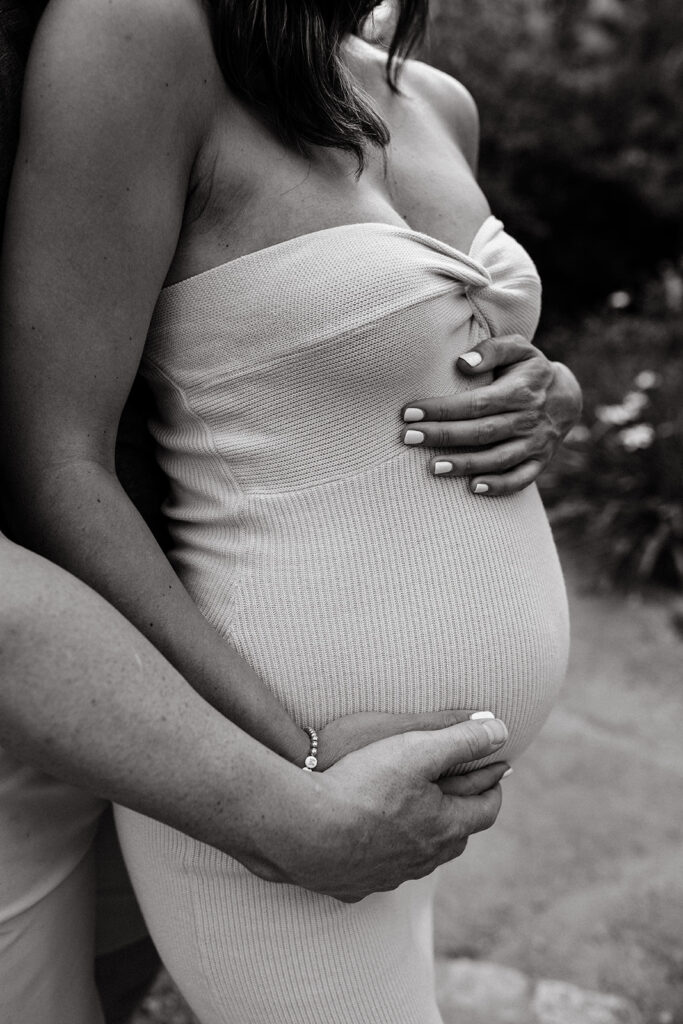 Mother and father holding pregnant belly during photoshoot