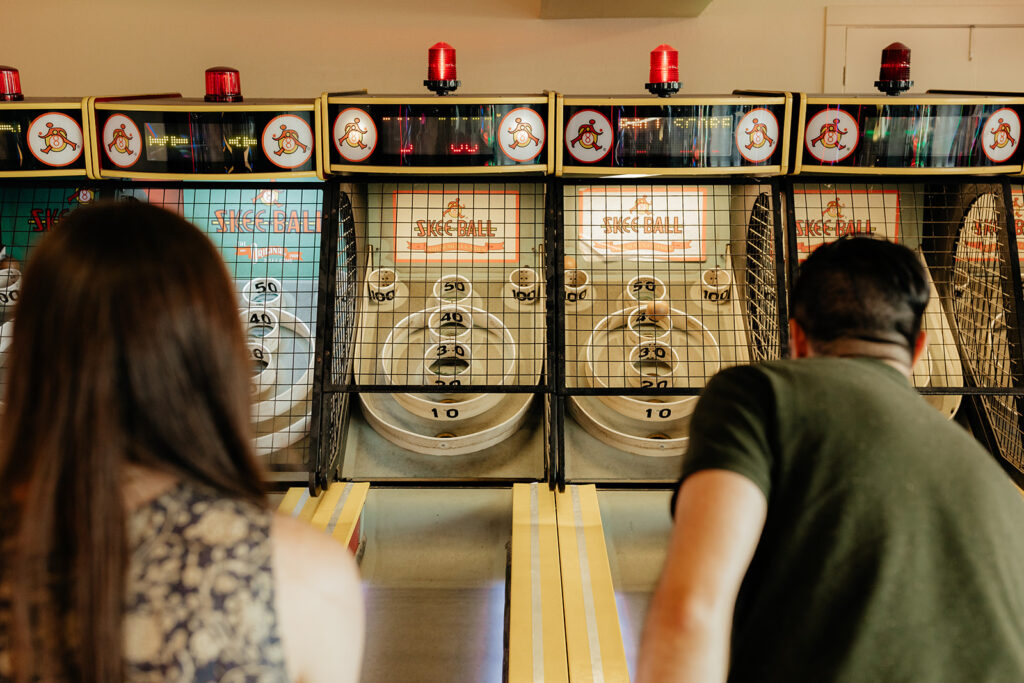 Couple playing skee ball at an arcade