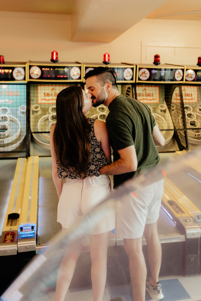 Couple playing skee ball at an arcade