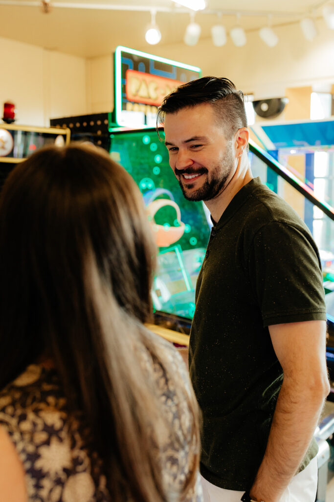 Couple playing skee ball at an arcade