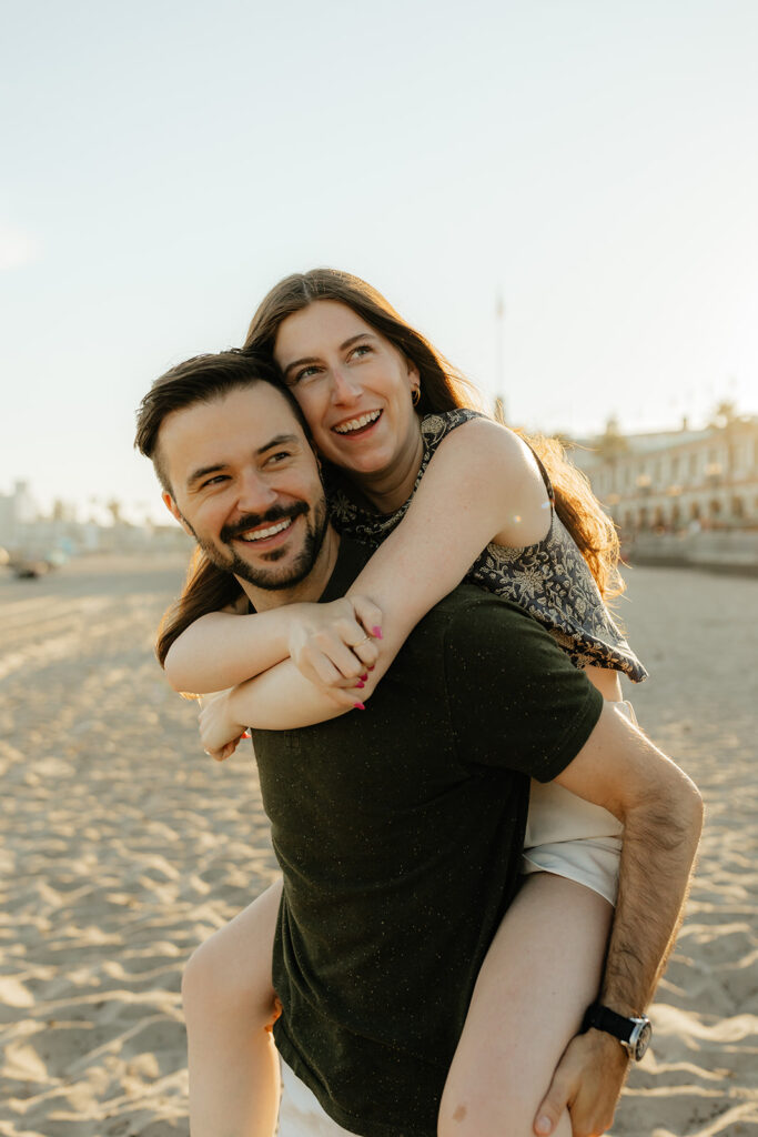 Couple running on the beach for Santa Cruz Beach engagement photos