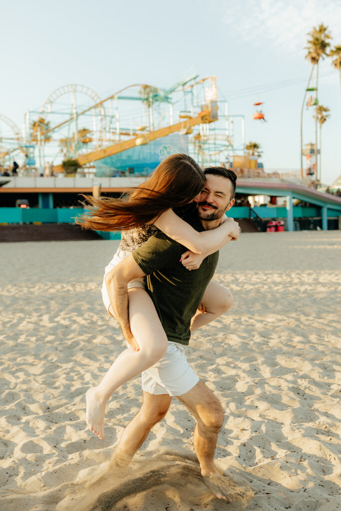 Couple running on the beach for Santa Cruz Beach engagement photos