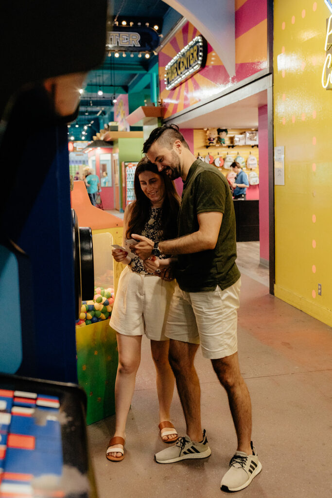 Couple playing skee ball at an arcade