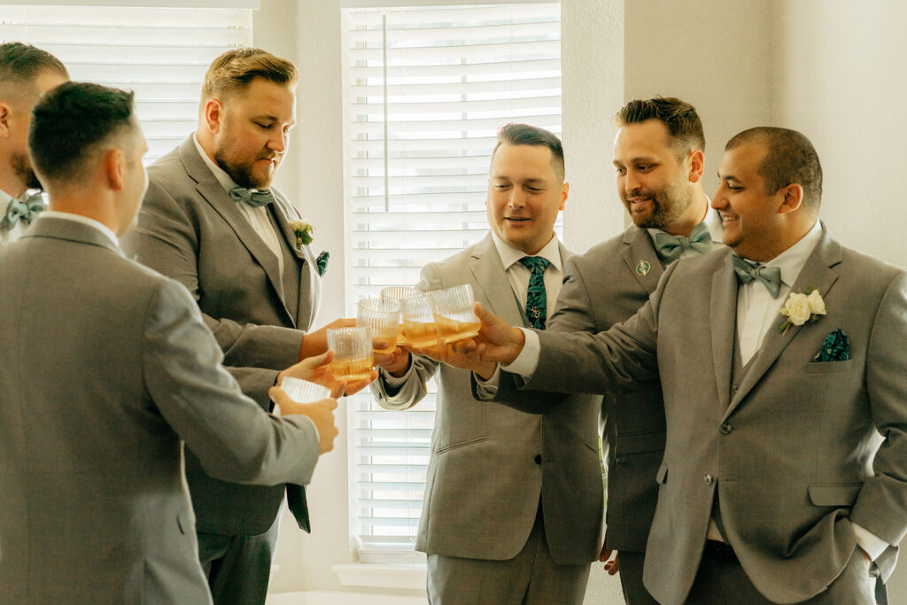 Groom and groomsmen toasting drinks before ceremony