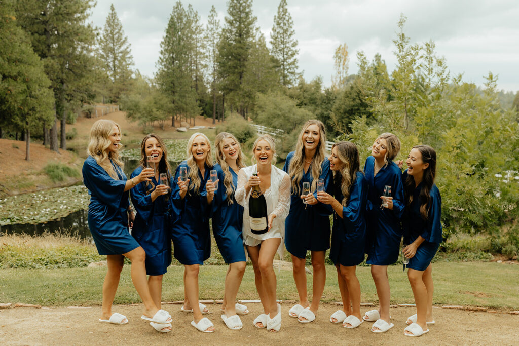 Bride and bridesmaids popping champagne 