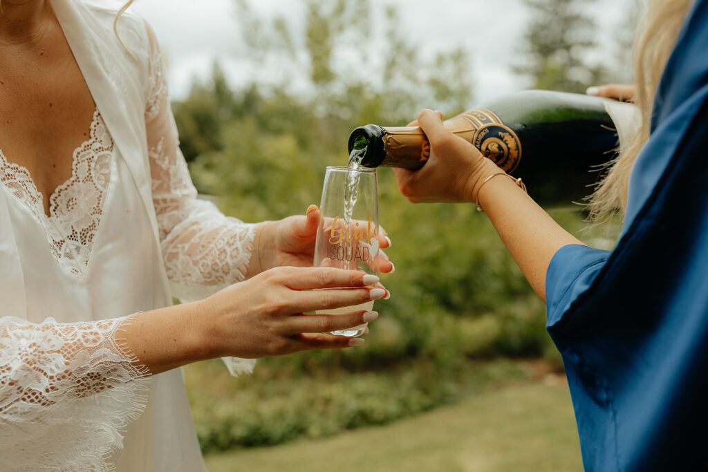 Bride and bridesmaids popping champagne 