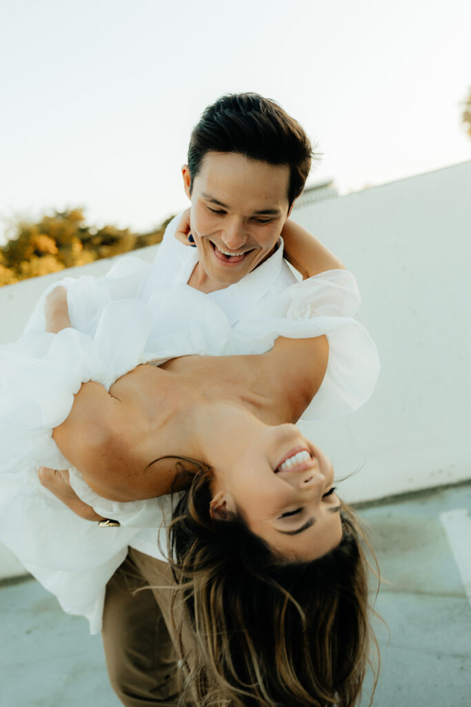 Playful couples rooftop downtown engagement photos in Sacramento