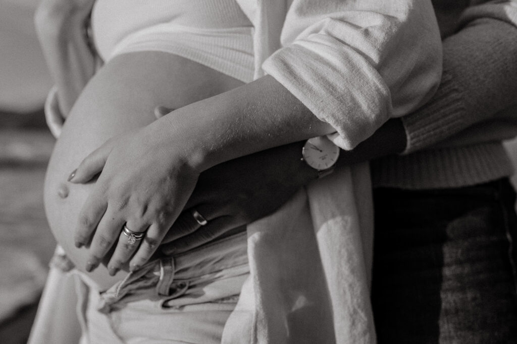 Man and woman holding pregnant belly 