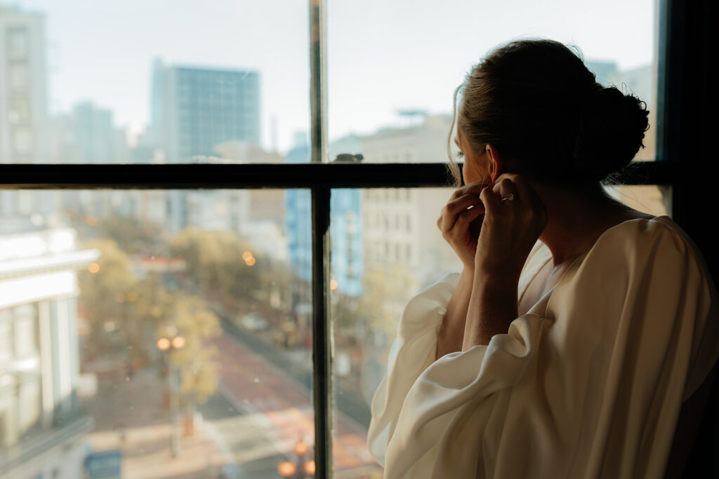 Bride looking out hotel window