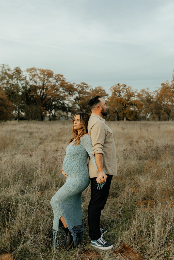 Man and woman posing for photos in a field
