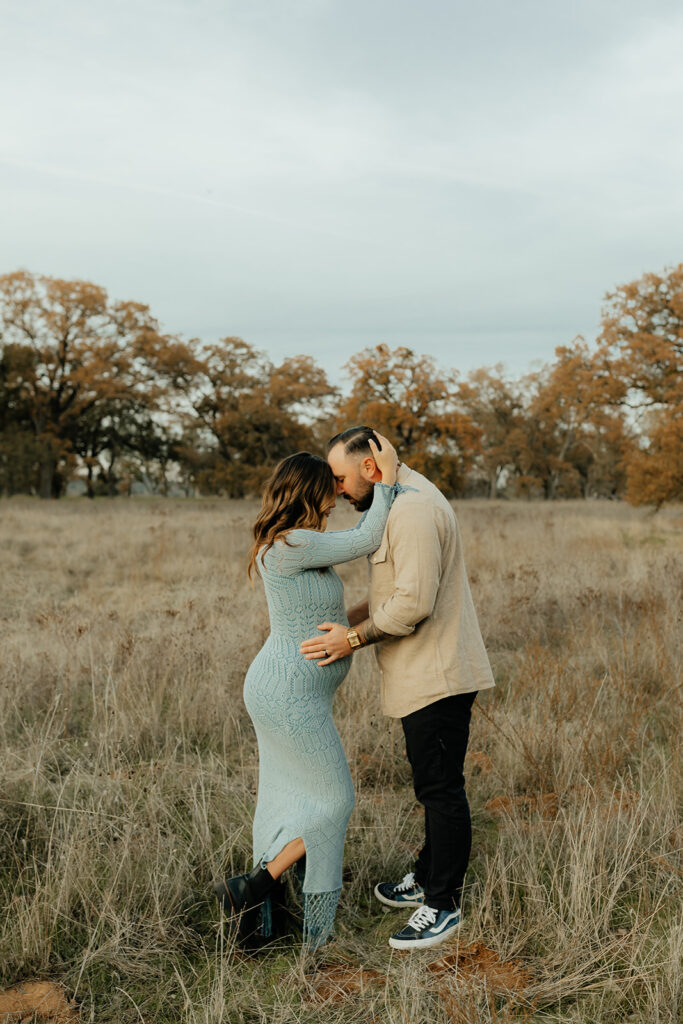 Man and woman posing for photos in a field