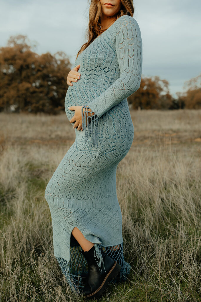Pregnant woman posing for photos in an open field