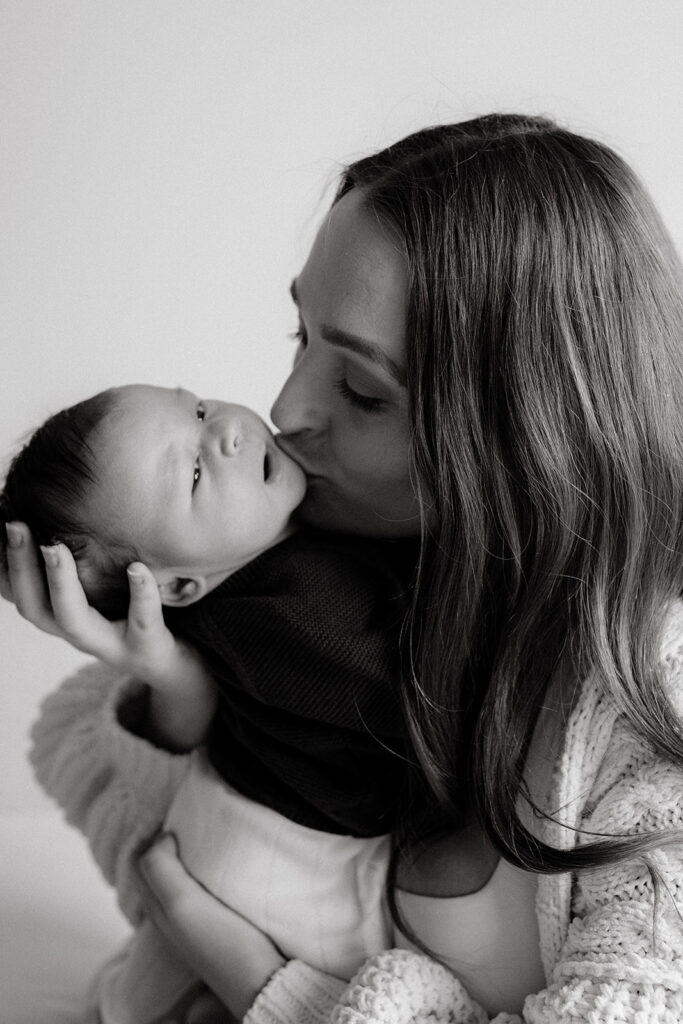 Mother kissing her new baby