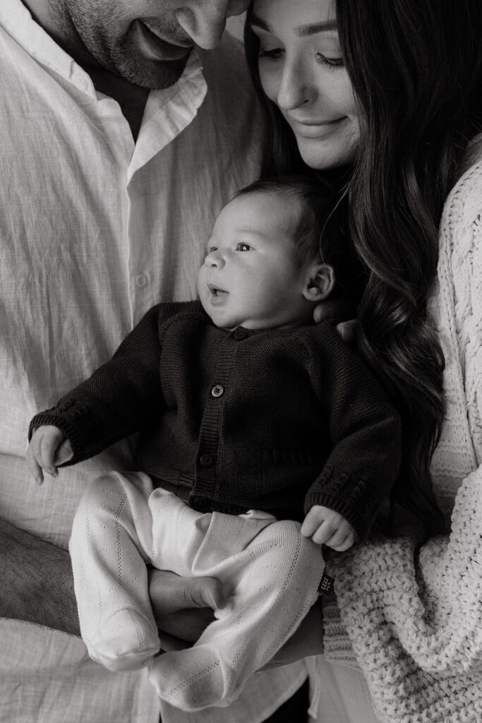 Mother, father, and baby boy during sweet at home newborn photography session in LA