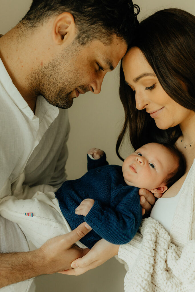 Mother, father, and baby boy during sweet at home newborn photography session in LA