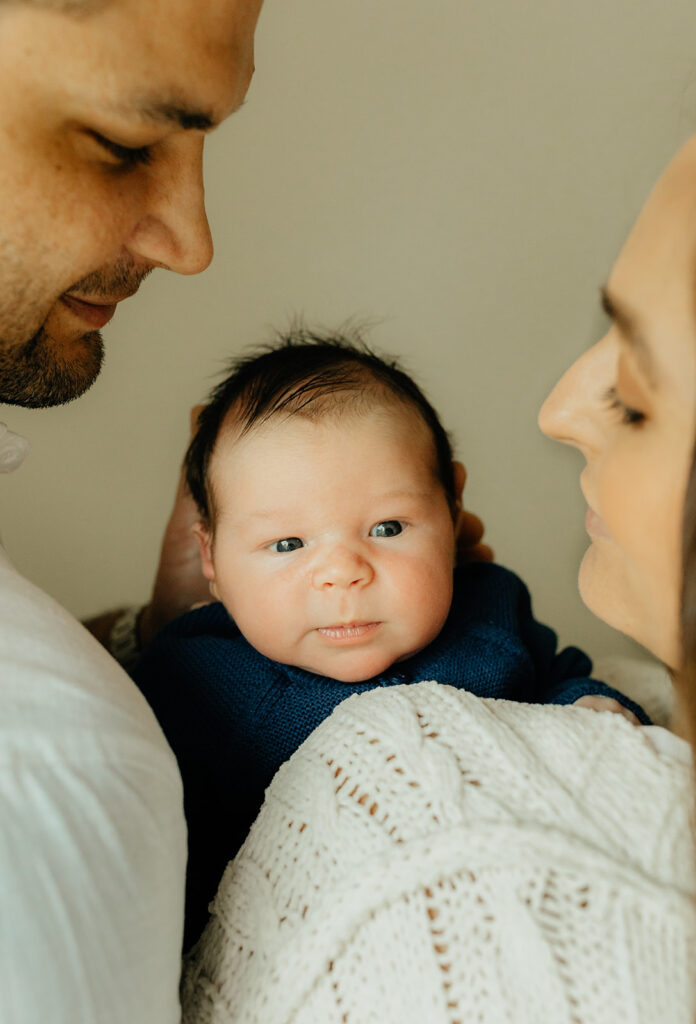 Mother, father, and baby boy during sweet at home newborn photography session in LA