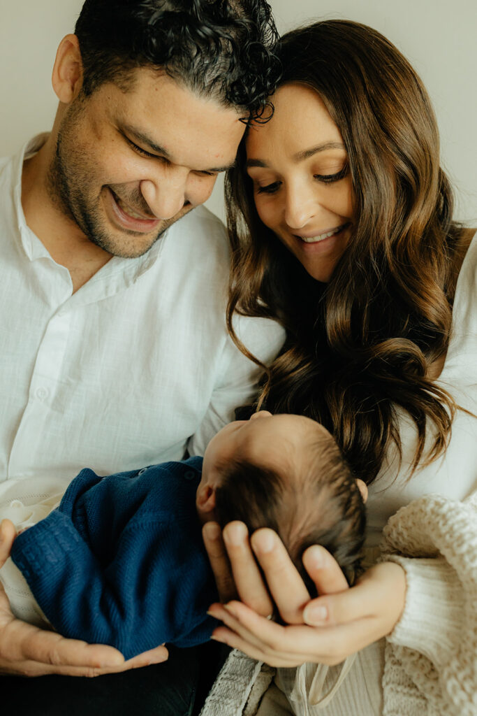 Mother, father, and baby boy during sweet at home newborn photography session in LA