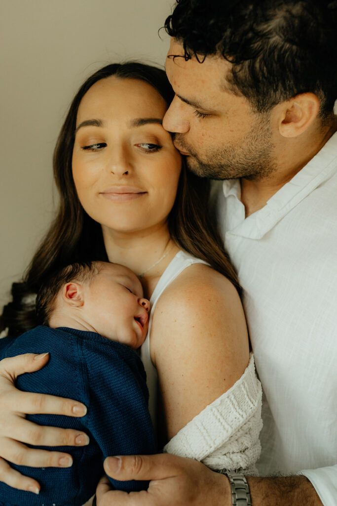 Mother, father, and baby boy during sweet at home newborn photography session in LA