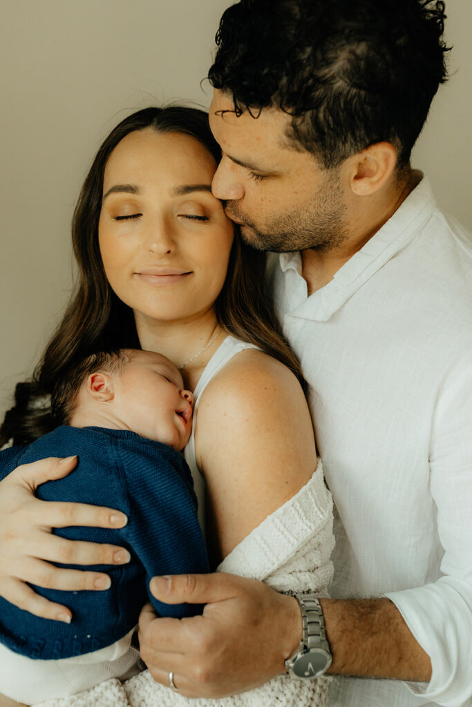 Mother, father, and baby boy during sweet at home newborn photography session in LA