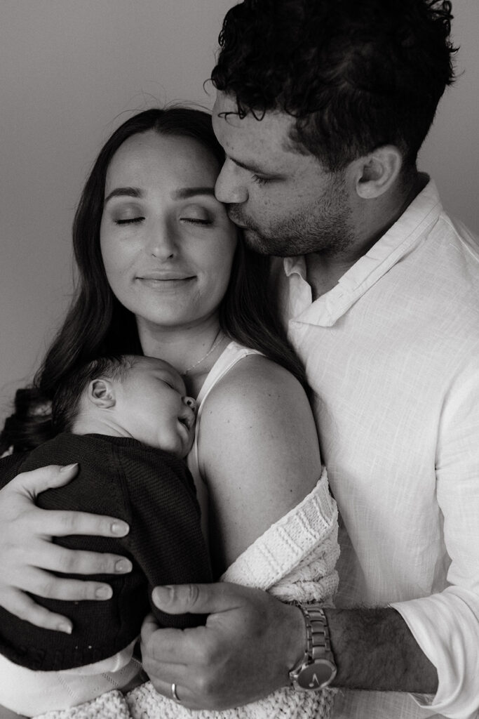 Mother, father, and baby boy during sweet at home newborn photography session in LA