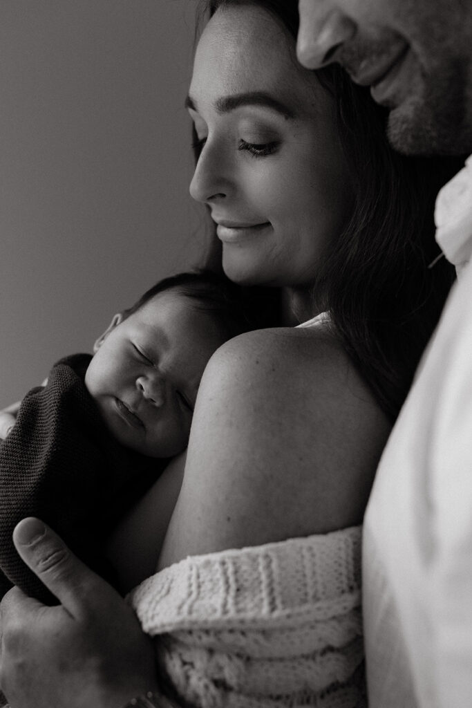 Mother, father, and baby boy during sweet at home newborn photography session in LA